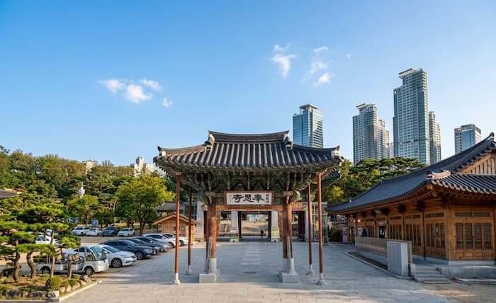 The entrance gate of Bongeunsa Temple in Seoul, with traditional wooden architecture framed by modern high-rise buildings in Gangnam