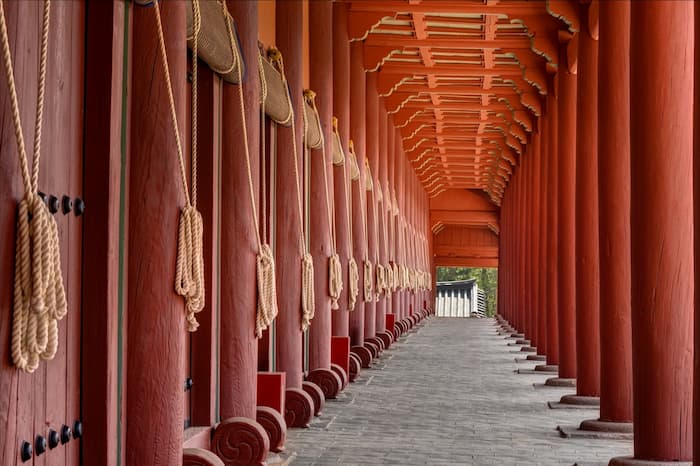 Photograph of the corridor at Jongmyo Shrine in Seoul with red wooden columns and a long receding passage