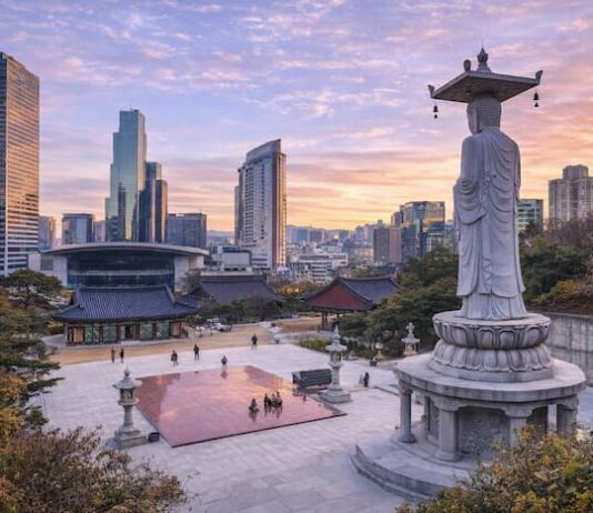Korean Temples ① Bongeunsa Bongeunsa Temple courtyard and standing Buddha statue with the Gangnam skyline at sunset in Seoul