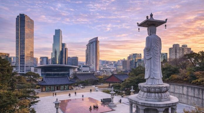 Korean Temples ① Bongeunsa Bongeunsa Temple courtyard and standing Buddha statue with the Gangnam skyline at sunset in Seoul