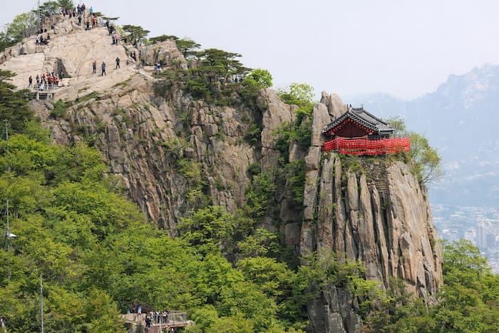 Yeonjudae on Gwanaksan standing above cliffs and the distant Seoul skyline