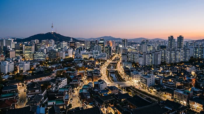 높은 곳에서 내려다본 서울 도심 거리와 차량, 건물, 횡단보도가 어우러진 도시 풍경.